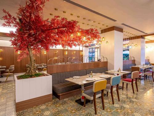 a restaurant with a table and a tree in the middle at Rixos Premium Belek - The Land of Legends Access in Belek