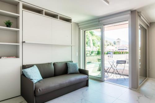 a living room with a couch and a sliding glass door at Locarno Studios by Quokka 360 - in the centre of Locarno in Locarno