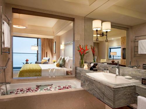 a bathroom with a bed and a tub and a sink at Fairmont Yangcheng Lake in Kunshan
