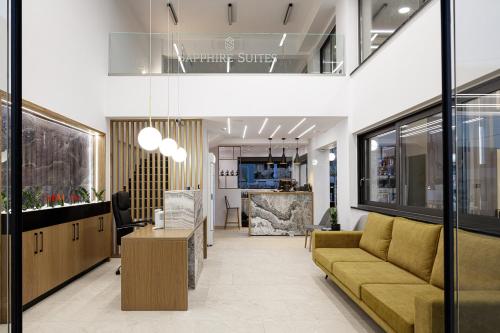 un vestíbulo de oficina con sofá y mesa en Sapphire Blue Suites en Kíssamos