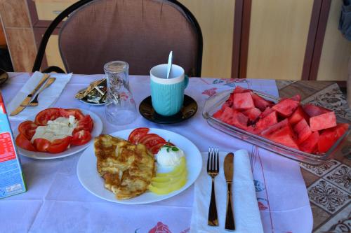 a table with plates of food and a tray of fruit at Guest House Vera in Ulcinj