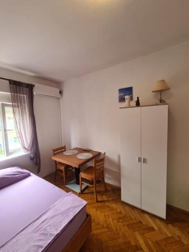 1 dormitorio con cama, mesa y armario en Michael's, en Zadar