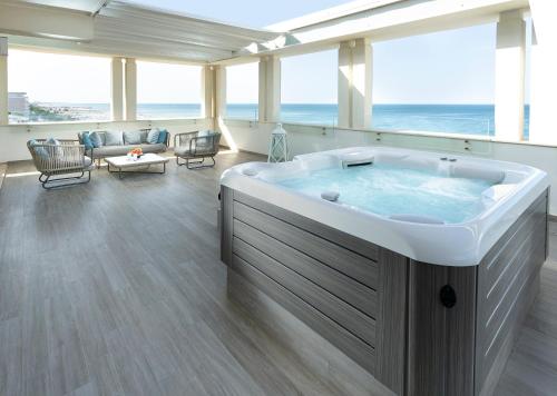 a large bath tub in a living room with the ocean at Hotel Ambasciatori in Riccione