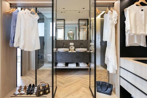 a bathroom with a glass closet with two sinks at Hotel Ambasciatori in Riccione