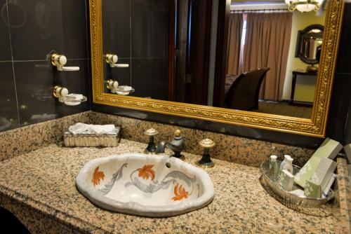 a bathroom with a sink with a gold framed mirror at Plaza del General in Tegucigalpa
