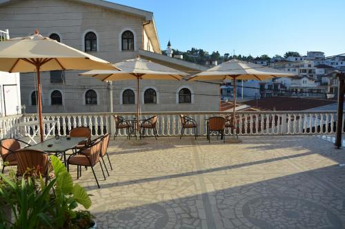 patio ze stołami, krzesłami i parasolami w obiekcie Guest House Vera w Ulcinju