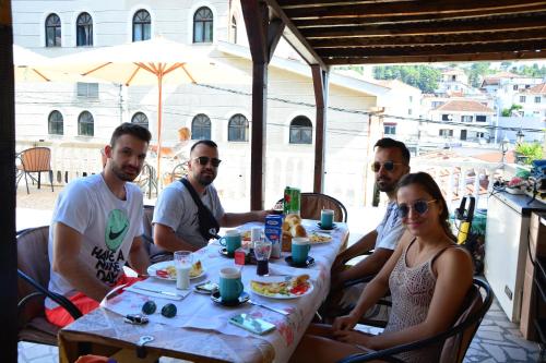 a group of people sitting at a table eating food at Guest House Vera in Ulcinj