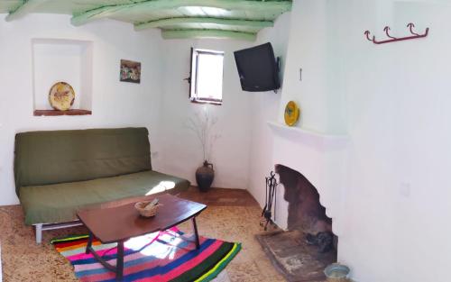 ein Wohnzimmer mit einem Sofa und einem Kamin in der Unterkunft La Morada de Higuera in Higuera de la Sierra