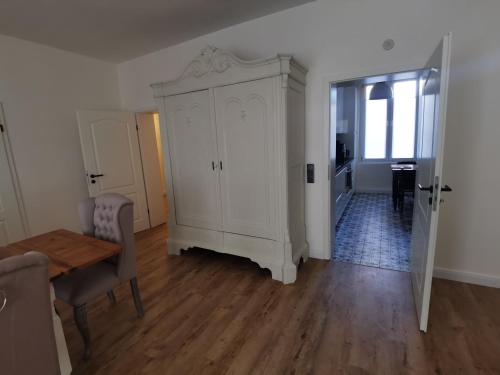 a living room with a large white cabinet and a table at Quedlinburg Marktplatz-Suites in Quedlinburg