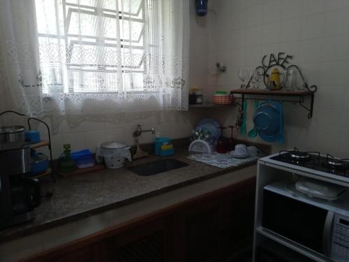 a kitchen counter with a sink and a window at Eco Chalés Águas Claras in Lumiar