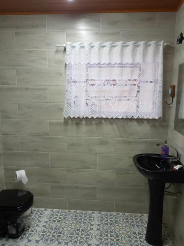 a bathroom with a sink and a toilet and a window at Eco Chalés Águas Claras in Lumiar