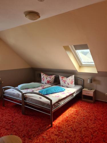 a attic bedroom with two beds and a window at Ferienwohnung Fiehn in Schwedt