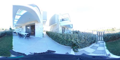 a house with a patio with a table in the yard at Hanioti suite maisonette in front of the sea in Hanioti