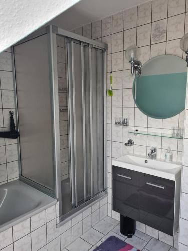 uma casa de banho com um chuveiro, um lavatório e um espelho. em Ferienwohnung Fiehn em Schwedt