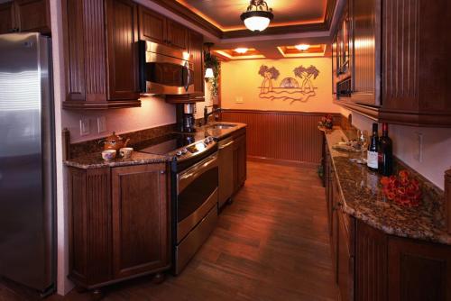 a kitchen with wooden cabinets and a stainless steel refrigerator at Biscayne Suites in Ocean City