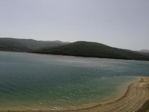 a large body of water with mountains in the background at Mavrovo Kjara Apartments in Mavrovo