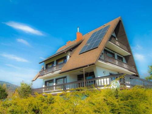 une maison avec un panneau solaire sur le toit dans l'établissement Apartament Rita, à Godziszka