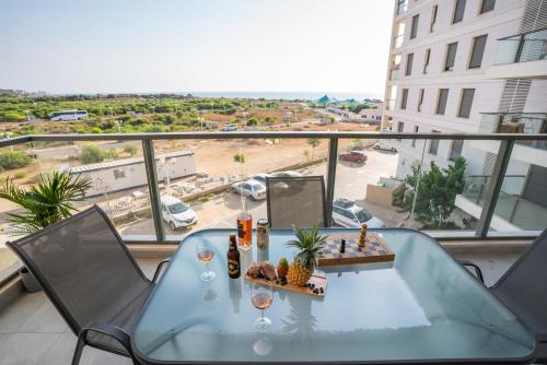a table on a balcony with a view of a parking lot at Achziv Beach Life with Stunning Sea Views by Sea N' Rent in Nahariyya