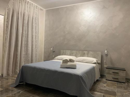 a bedroom with a bed with two towels on it at Le Stanze della Braceria Calabrese in Scilla