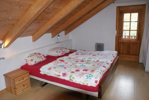 a bedroom with a bed with a red blanket and pillows at Rustikale und grosszügige Ferienwohnung in Kašperské Hory