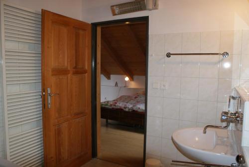 a bathroom with a sink and a door to a bedroom at Rustikale und grosszügige Ferienwohnung in Kašperské Hory