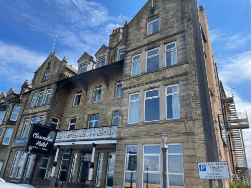 a large stone building on the corner of a street at The Clarendon Hotel in Morecambe