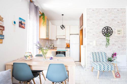 a kitchen with blue chairs and a wooden table at PK Luxury Apartment, feels like home in Alexandroupoli