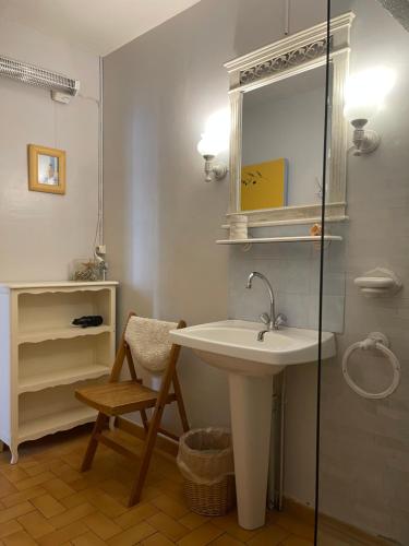 une salle de bain avec un lavabo, un miroir et une chaise dans l'établissement Montagne d'Alaric, à Moux