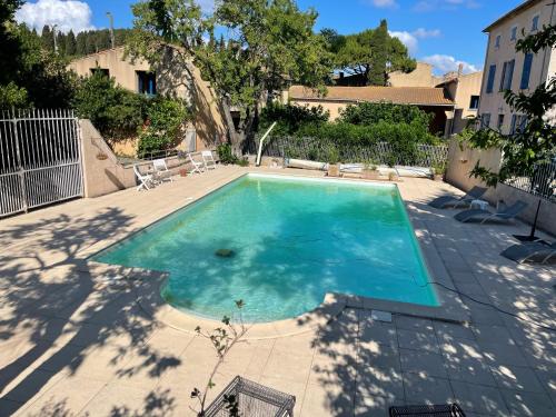 une piscine avec de l'eau bleue dans une cour dans l'établissement Montagne d'Alaric, à Moux