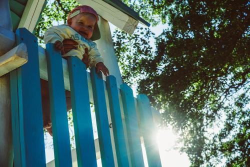 a child leaning over a blue fence at Lake Park Łagów in Łagów