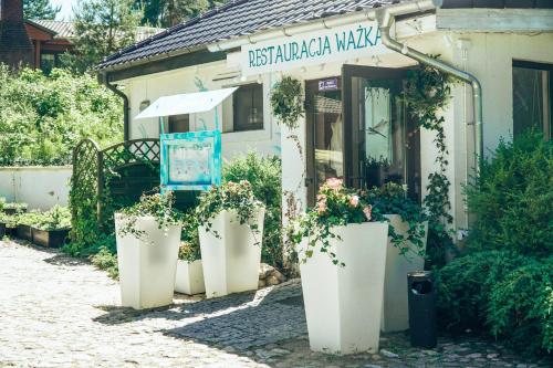 a store with potted plants in front of a building at Lake Park Łagów in Łagów