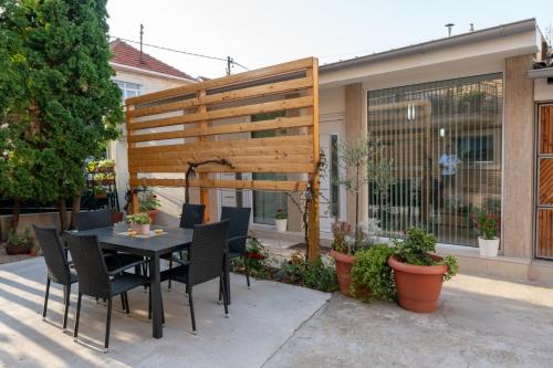 a patio with a table and chairs in front of a house at Prestige Apartments in Niš