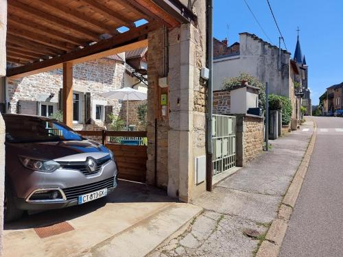 a car parked outside of a house with an umbrella at L'INATTENDU Vue imprenable,clim,parking avec borne de recharge, ménage inclus in Montaigu