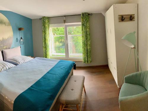 1 dormitorio con 1 cama, 1 silla y 1 ventana en Ferienwohnungen Zur Biberburg, en Friedrichswalde