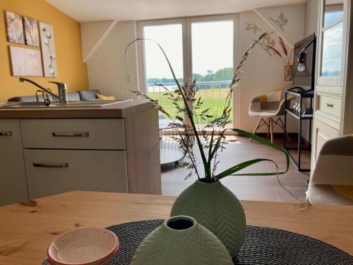 a green vase sitting on a table in a kitchen at Ferienwohnungen Zur Biberburg in Friedrichswalde