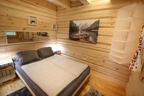 ein Schlafzimmer mit einem Bett in einem Blockhaus in der Unterkunft Blockhaus Chalet mit eigenem Badefass und Infrarotsauna auf der Terrasse in Oberschützen