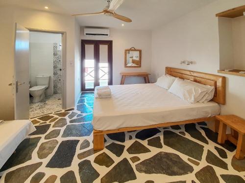 a bedroom with a bed and a bathroom at Dendrinos House in Galissas