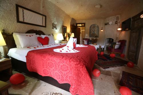 um quarto com uma cama com um cobertor vermelho em Turkish Cave House em Ortahisar