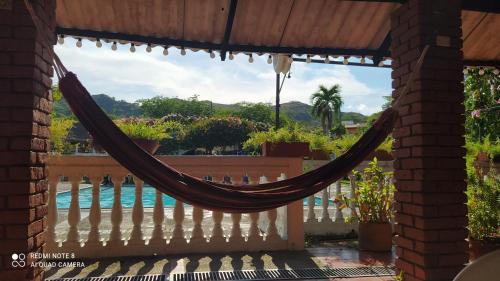 a hammock on a porch with a view of a pool at Meson Hondano in Honda