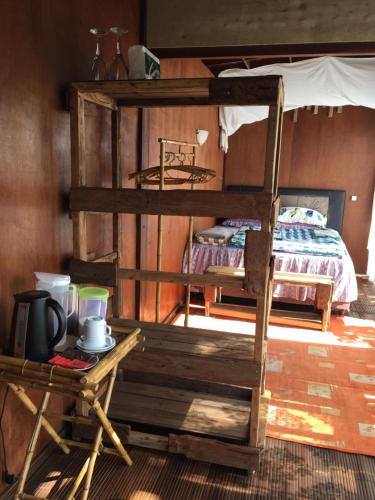 um quarto com 2 beliches e uma mesa em jungleadventure cabin camping em Bedugul