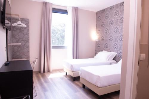 a bedroom with a white bed and white walls at Hotel Della Rosa in Ancona
