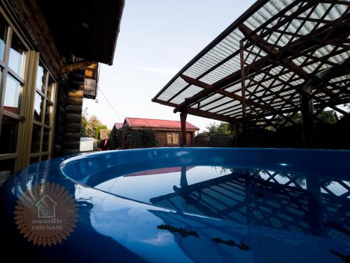 a large blue pool in a house with a roof at Guest house Zvejnieksēta in Pāvilosta