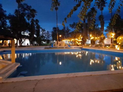 a night view of a swimming pool with lights at OYO Hotel Oasis, Matehuala in Matehuala