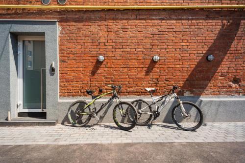 CAPSULE HOTEL & HOSTEL في خاركوف: اثنين من الدراجات متوقفة بجوار جدار من الطوب
