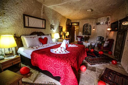 a bedroom with a large bed with a red blanket at Turkish Cave House in Ortahisar