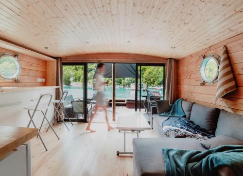 a woman walks through the living room of a tiny house at Les Toues Cabanées du lac in Le Sauze-du-Lac