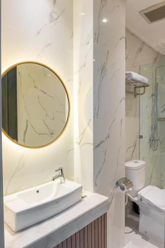 a bathroom with a sink and a mirror at Kala Hotel Semarang in Jomblang