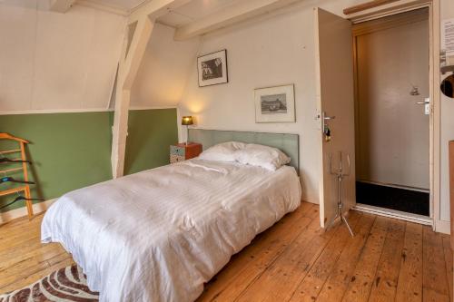 a bedroom with a bed with white sheets on it at B&B 1971 Hazenstraat - Shared Bathroom in Amsterdam