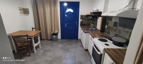 a kitchen with a blue door and a stove at Carpe diem in Galatas