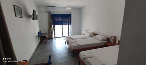 a hotel room with two beds and a balcony at Carpe diem in Galatas